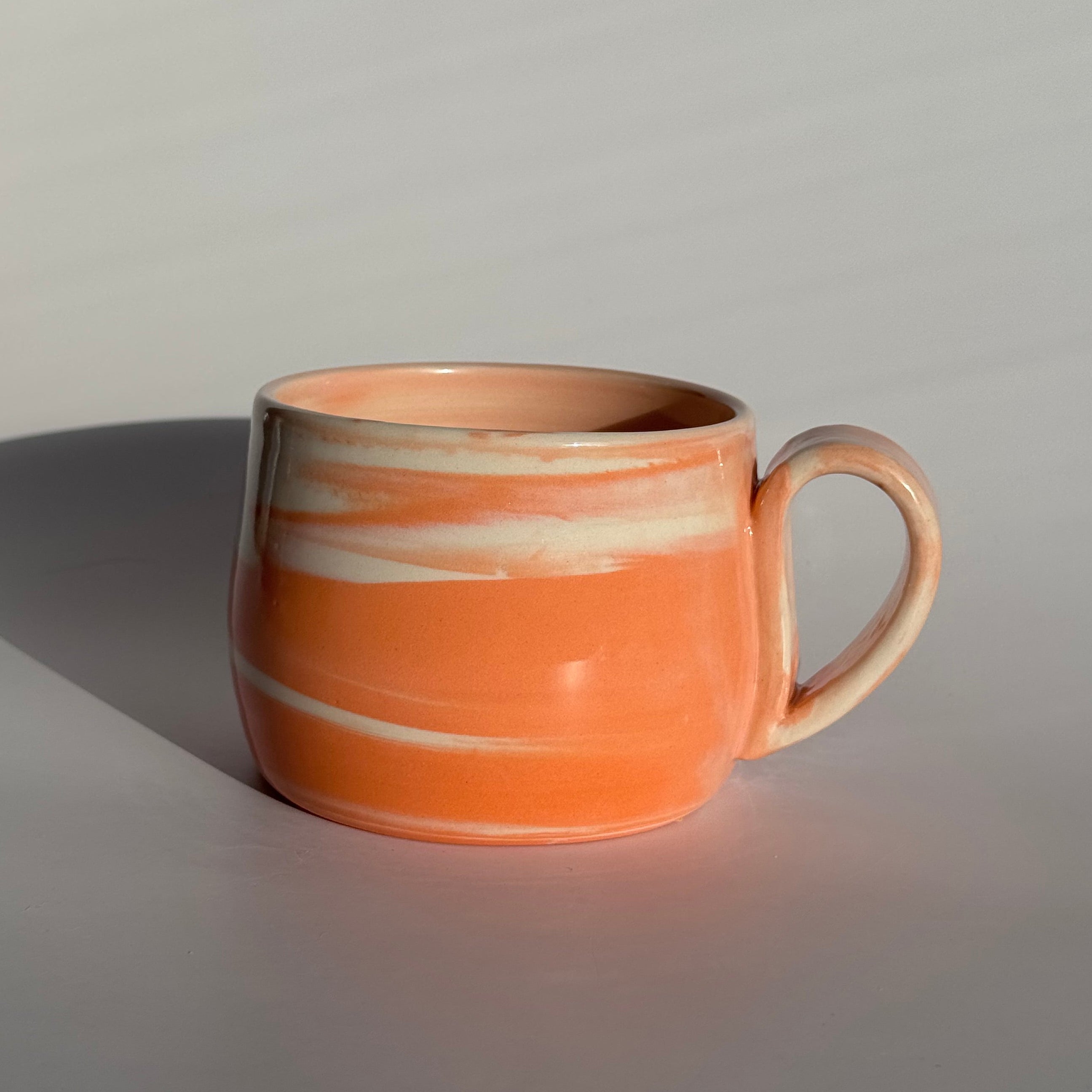 Ceramic cup with marbled design on a gray background