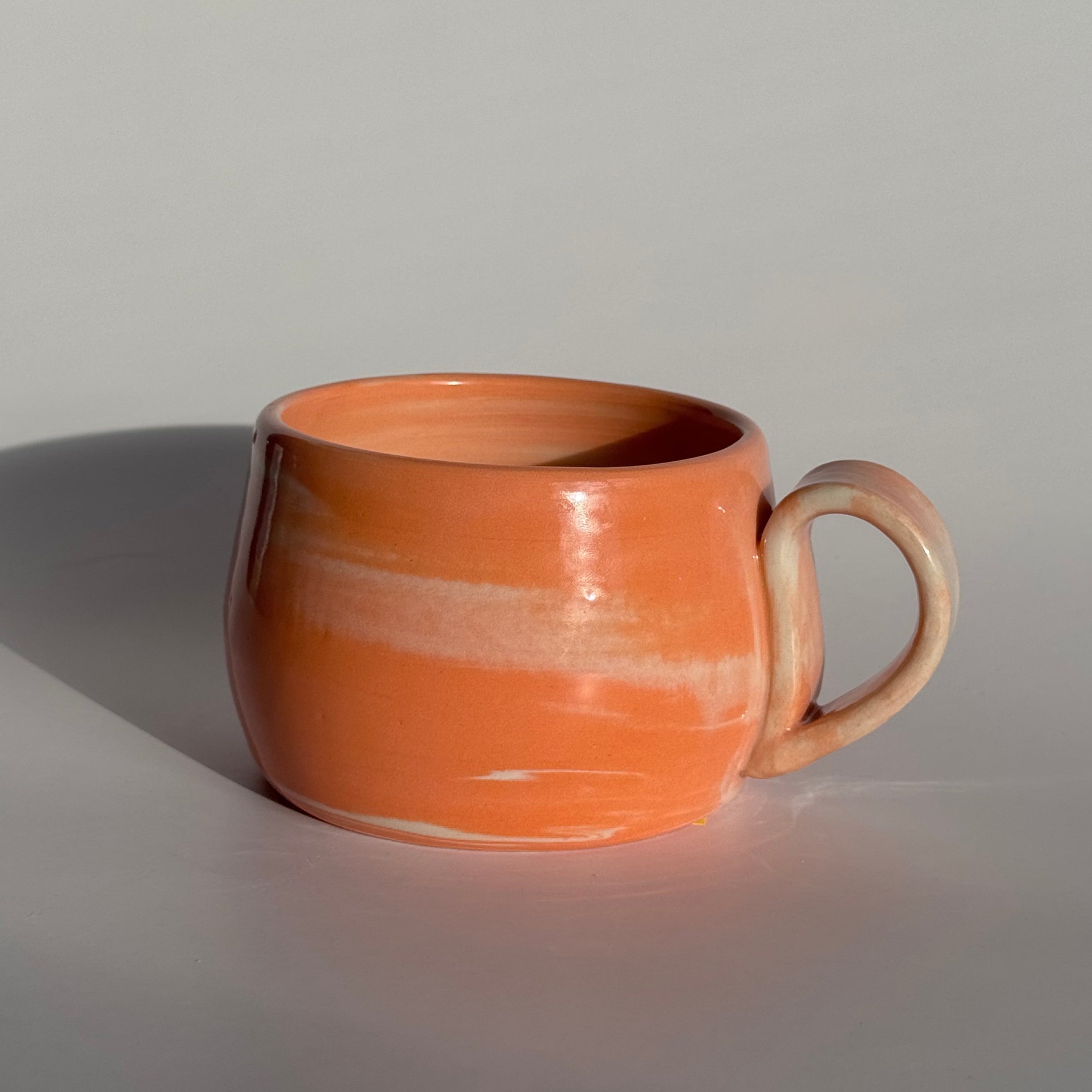 Ceramic cup with handle on a gray background