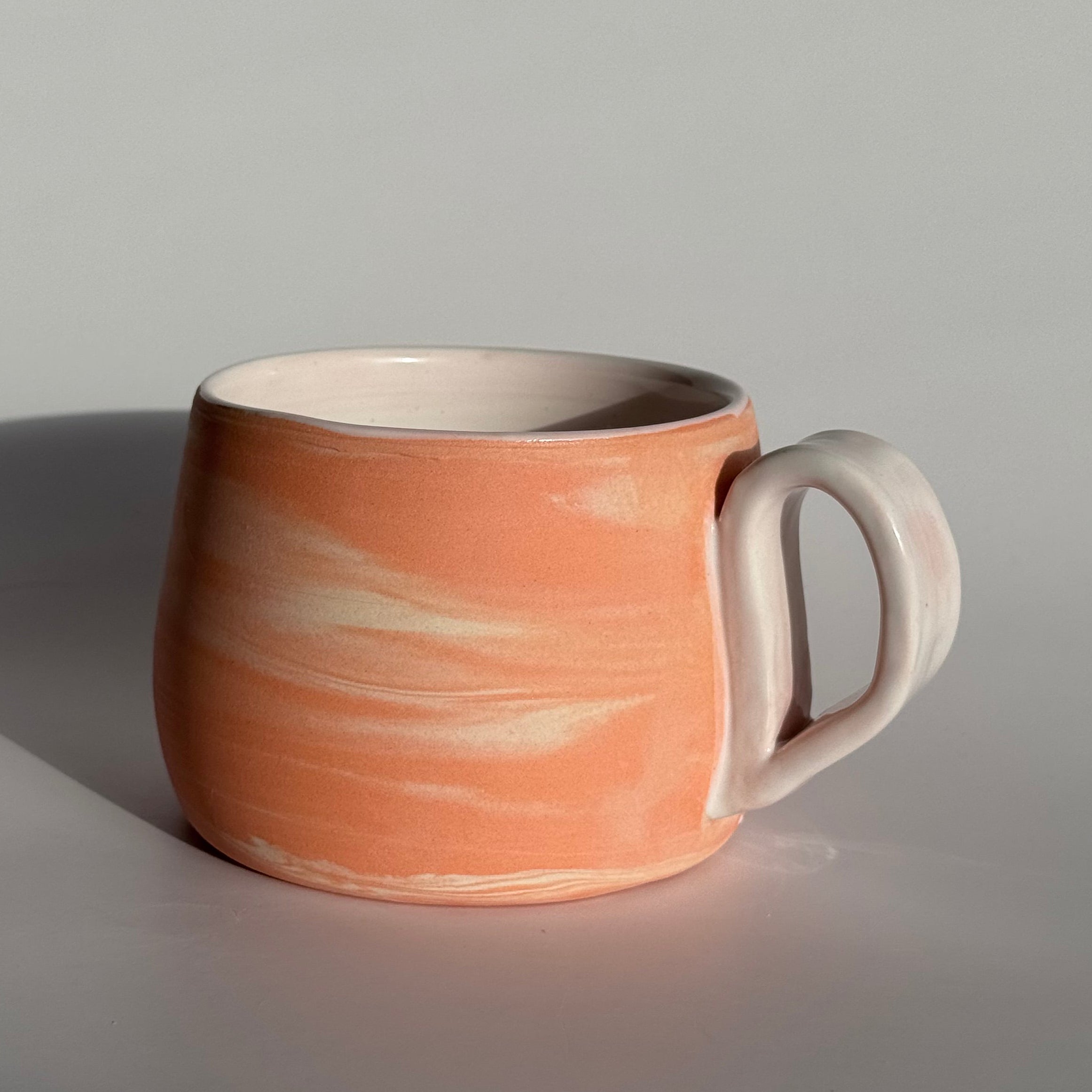 Ceramic mug with a marbled design on a gray background