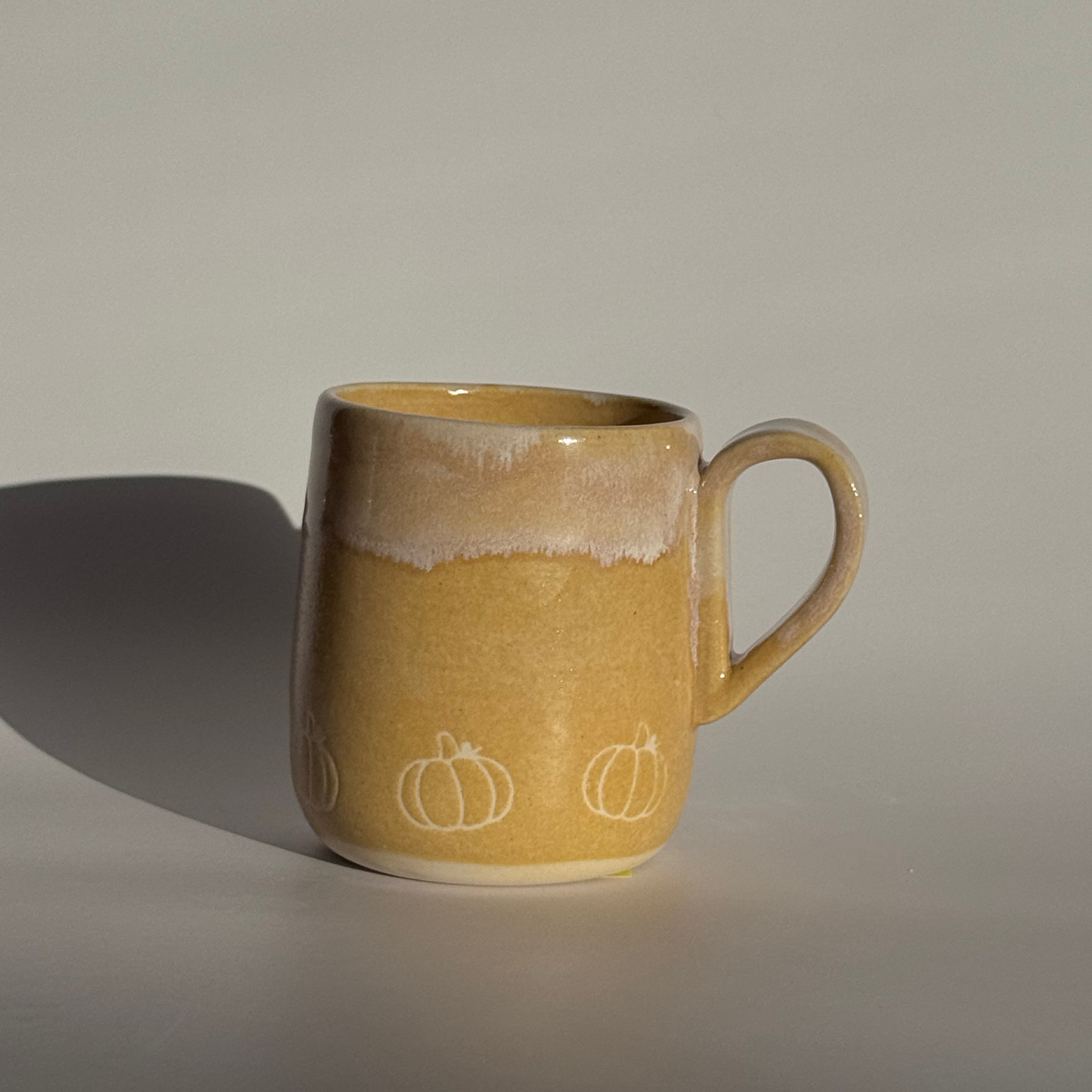 Yellow ceramic mug with a handle on a gray background