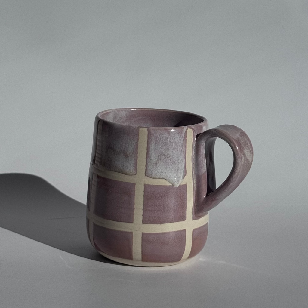 Ceramic mug with checkered pattern on a gray background