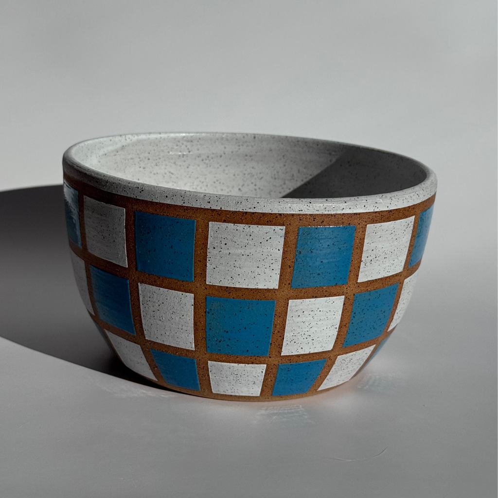 Ceramic bowl with checkered pattern on a gray background