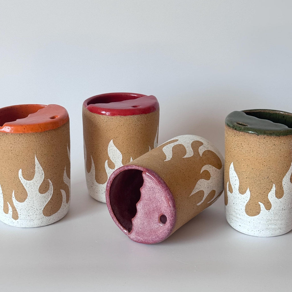 Set of ceramic cylindrical vases with flame patterns on a white background